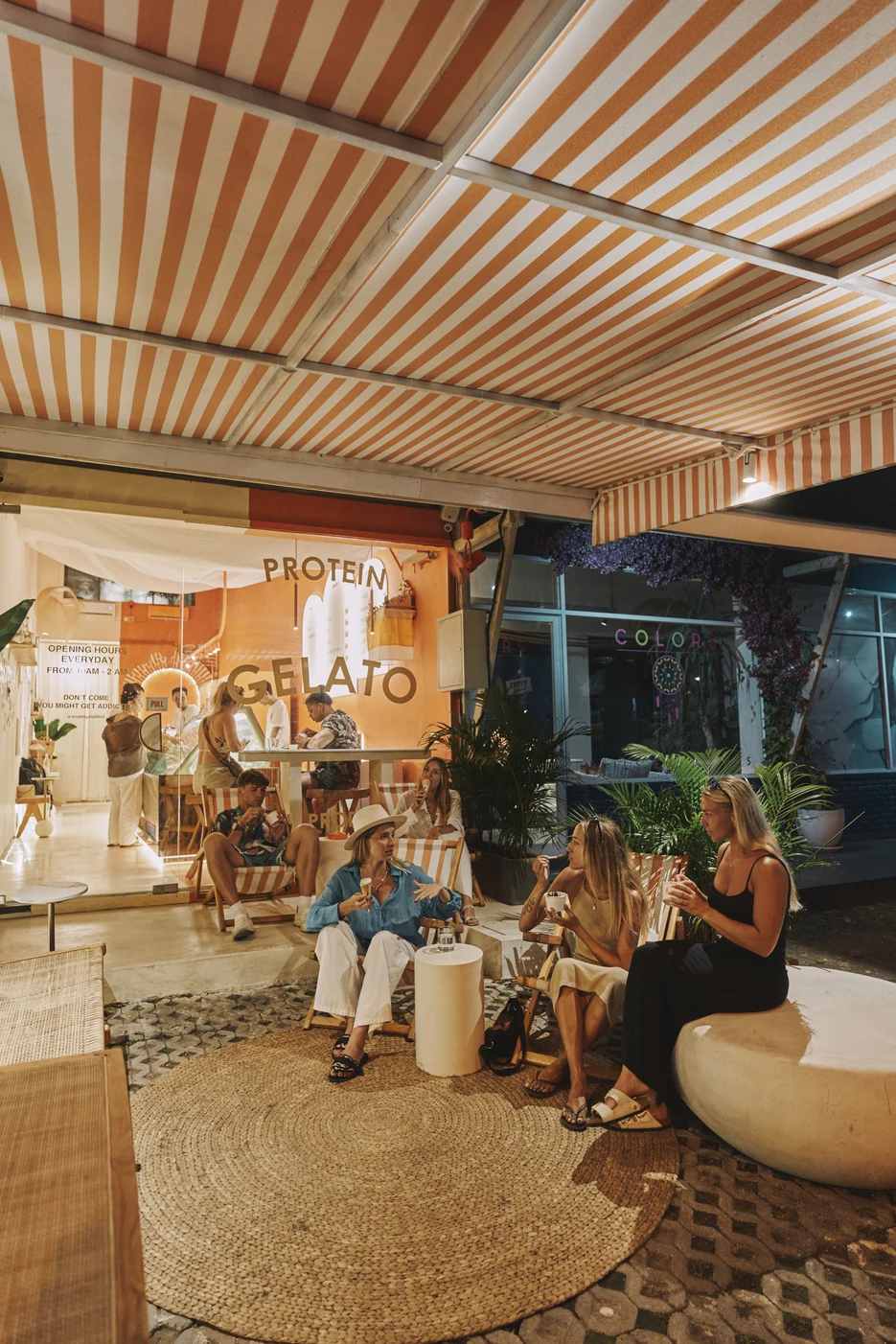 The finished boutique terrace with striped awning and guests